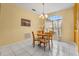 Cozy dining area features a round wooden table with four chairs and a large window with curtains at 507 Westwind Dr, Davenport, FL 33896