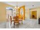 Dining area with a round wooden table set, chandelier, and a large window with sheer curtains at 507 Westwind Dr, Davenport, FL 33896