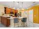 Well-lit kitchen with wooden cabinets, marble countertops, pendant lights, and modern bar stools at 507 Westwind Dr, Davenport, FL 33896