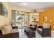 Bright living room showcasing comfortable wicker furniture, leading to an outdoor pool at 507 Westwind Dr, Davenport, FL 33896
