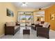 Comfortable living room leading to an outdoor pool area, featuring wicker furniture and bright walls at 507 Westwind Dr, Davenport, FL 33896
