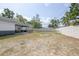 Large backyard with a white fence, partially grassed, and some recreational play equipment at 528 Courtland Blvd, Deltona, FL 32738