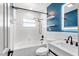 Bathroom with white tiling, contrasting blue accent wall, and modern fixtures at 5338 Tangerine Ave, Winter Park, FL 32792
