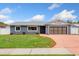 Charming single-story home featuring a brick driveway, gray facade and well-maintained lawn at 5338 Tangerine Ave, Winter Park, FL 32792