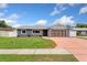 Charming single story home with brick driveway, manicured lawn, and gray exterior paint at 5338 Tangerine Ave, Winter Park, FL 32792