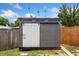 A modern, grey shed with a white sliding door and small windows at 5338 Tangerine Ave, Winter Park, FL 32792