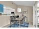 Dining area with a glass table, modern chairs, and view of the renovated kitchen at 5395 Dover Village Ln # 305, Orlando, FL 32812