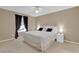 Comfortable bedroom features a large window offering natural light, complemented by a ceiling fan and simple decor at 5395 Dover Village Ln # 305, Orlando, FL 32812