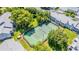 Aerial view featuring community tennis courts surrounded by trees and landscaping, with condo buildings in the background at 5395 Dover Village Ln # 305, Orlando, FL 32812