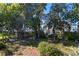 Lush backyard landscape with mature trees leads to private dock and waterfront at 557 Lake Cove Pointe Cir, Winter Garden, FL 34787
