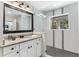 Well-lit bathroom features white cabinets, granite countertops, and a modern shower with a view at 557 Lake Cove Pointe Cir, Winter Garden, FL 34787