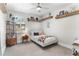 Inviting bedroom with a cozy bed, open shelves, and bright natural light from the window at 557 Lake Cove Pointe Cir, Winter Garden, FL 34787