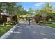 Gated community entrance featuring brick pillars, black wrought iron, and mature landscaping at 557 Lake Cove Pointe Cir, Winter Garden, FL 34787