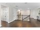 Upstairs hallway with dark wood floors and decorative iron railing, leading to various rooms at 557 Lake Cove Pointe Cir, Winter Garden, FL 34787