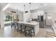 Bright, open kitchen with stainless steel appliances, white cabinets, a large island, and a view of the screened pool at 557 Lake Cove Pointe Cir, Winter Garden, FL 34787