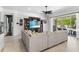Bright living room showcasing a large sectional, dark wood entertainment center and access to a pool area at 557 Lake Cove Pointe Cir, Winter Garden, FL 34787