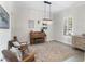 Bright and airy living room with a crystal chandelier and seating around an ornate, antique piano at 557 Lake Cove Pointe Cir, Winter Garden, FL 34787
