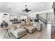 Bright, spacious living room featuring a sectional sofa, ceiling fan, and a view into the kitchen and stairway at 557 Lake Cove Pointe Cir, Winter Garden, FL 34787