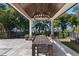 Covered outdoor dining area featuring a large table, chandelier, and serene backyard views at 557 Lake Cove Pointe Cir, Winter Garden, FL 34787