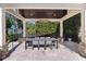 Covered outdoor dining area featuring a large table, chandelier, and lush backyard landscaping at 557 Lake Cove Pointe Cir, Winter Garden, FL 34787