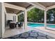 Covered outdoor patio with furniture overlooking the pool and manicured backyard at 557 Lake Cove Pointe Cir, Winter Garden, FL 34787