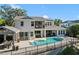 Rear exterior of the home features a swimming pool, hot tub, balcony, and covered outdoor seating at 557 Lake Cove Pointe Cir, Winter Garden, FL 34787