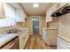 Bright kitchen features white cabinets, stainless steel sink, and modern countertops, with wood-look vinyl flooring at 635 San Lanta Cir, Sanford, FL 32771