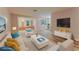 Bright, virtually staged living room with light hardwood floors, comfortable seating, and a modern entertainment center at 635 San Lanta Cir, Sanford, FL 32771