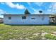 Back exterior view of a light blue home featuring newer windows and well kept lawn at 642 Carver Dr, Lake Wales, FL 33853