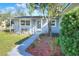 Cozy home entrance featuring a charming porch with seating, lush landscaping, and a freshly painted exterior at 642 Carver Dr, Lake Wales, FL 33853