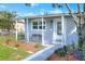 Close up of a cozy covered porch, showing a charming seating area, and meticulous landscaping at 642 Carver Dr, Lake Wales, FL 33853