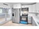 Open kitchen with stainless steel appliances, breakfast bar, and light countertops and gray cabinets at 642 Carver Dr, Lake Wales, FL 33853