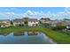 Backyard view overlooking a pond with green grass and a black metal fence, providing serene outdoor space at 646 Marsh Reed Dr, Winter Garden, FL 34787