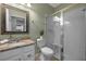 Charming bathroom featuring a framed mirror, granite vanity, white cabinets and walk-in shower with glass door at 646 Marsh Reed Dr, Winter Garden, FL 34787