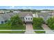 Charming two-story home featuring a well-manicured lawn, brick driveway, and lush landscaping at 646 Marsh Reed Dr, Winter Garden, FL 34787
