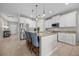 Beautiful kitchen island with barstool seating, granite countertops, stainless steel appliances, and classic pendant lighting at 646 Marsh Reed Dr, Winter Garden, FL 34787