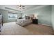 Spacious main bedroom with a large window, ceiling fan, and a king-sized bed at 646 Marsh Reed Dr, Winter Garden, FL 34787