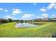 Scenic view of a tranquil pond reflecting the sky, surrounded by well-maintained lawns and homes at 646 Marsh Reed Dr, Winter Garden, FL 34787