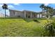 Well-maintained backyard with green grass and gray exterior at 725 N Grandview Ave, Daytona Beach, FL 32118