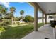 Covered patio overlooking the green backyard with palm trees at 725 N Grandview Ave, Daytona Beach, FL 32118