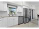 Well-lit kitchen showcasing stainless steel refrigerator and view to the outside at 725 N Grandview Ave, Daytona Beach, FL 32118