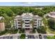 Aerial view of the property showcasing the building, landscaping, and parking at 7660 Whisper Way # 402, Reunion, FL 34747