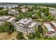 Aerial view showcases building, balconies, mature trees, and surrounding community at 7660 Whisper Way # 402, Reunion, FL 34747