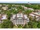 Aerial view showcases building, balconies, mature trees, and surrounding community at 7660 Whisper Way # 402, Reunion, FL 34747