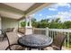 A covered balcony features seating and views of the surrounding nature at 7660 Whisper Way # 402, Reunion, FL 34747