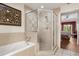 Well-lit bathroom featuring a tub and separate glass-enclosed shower, offering convenience and style at 7660 Whisper Way # 402, Reunion, FL 34747
