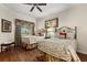Bright bedroom features two beds, wood floors, ceiling fan, and large window at 7660 Whisper Way # 402, Reunion, FL 34747