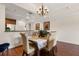 Cozy dining area featuring hardwood floors, a chandelier, and a view into the kitchen, creating an inviting atmosphere at 7660 Whisper Way # 402, Reunion, FL 34747