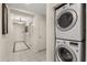 Hallway featuring the stacked washer and dryer. Tiled floors and neutral paint at 7660 Whisper Way # 402, Reunion, FL 34747