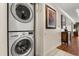 Stacked white washer and dryer with a view of the hallway beyond at 7660 Whisper Way # 402, Reunion, FL 34747